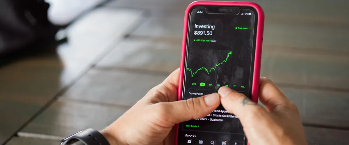 Iemand bekijkt een beleggingsapp op een smartphone